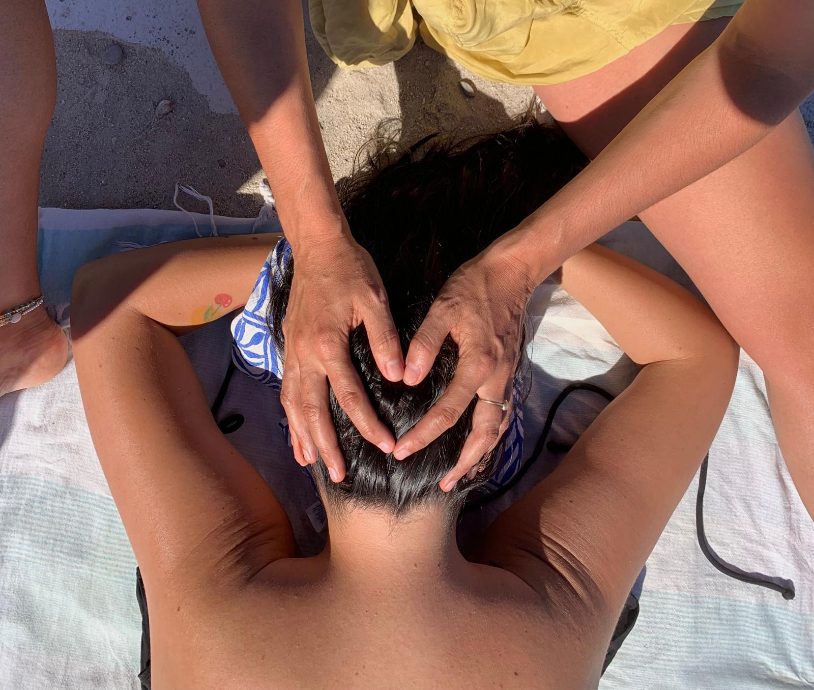 Hands forming a heart on a person's head during a massage